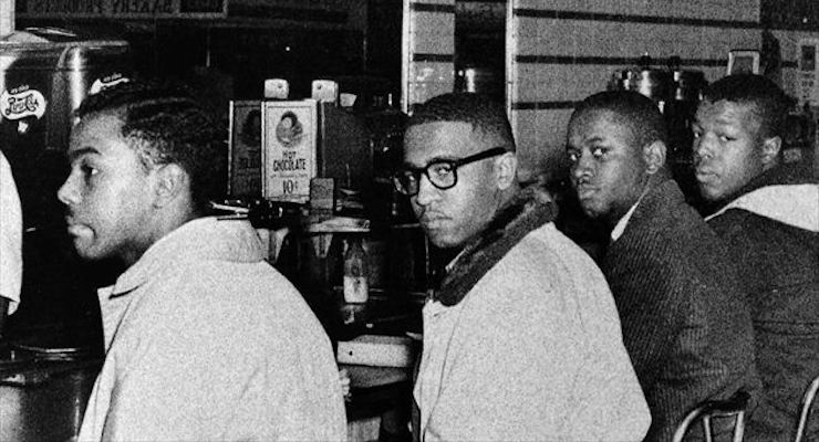 On the second day of the Greensboro sit-in, Joseph A. McNeil and Franklin E. McCain are joined by William Smith and Clarence Henderson at the Woolworth lunch counter in Greensboro, North Carolina. (Courtesy of Greensboro News and Record)