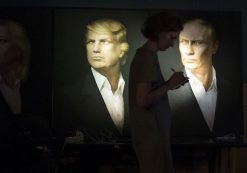 A journalist writes a material as she watches a live telecast of the U.S. presidential election standing at portraits of U.S. presidential candidate Donald Trump and Russian President Vladimir Putin in the Union Jack pub in Moscow, Russia, Wednesday, Nov. 9, 2016. Russia's lower house of parliament is applauding the election of Trump as U.S. president. (Photo: AP)