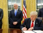 U.S. President Donald Trump, signs his first executive orders at the White House on Friday. Behind him, from left, are senior adviser Jared Kushner, Vice President Mike Pence and staff secretary Rob Porter. (Photo: Reuters)