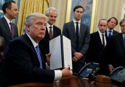 President Donald Trump shows his signature on an executive order in the Oval Office in Washington. (Photo: AP)