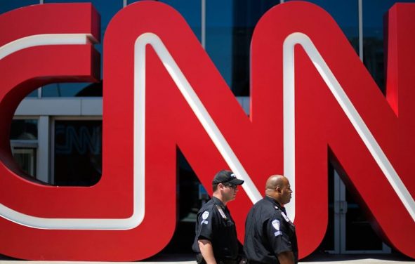 Security guards walk past the entrance to CNN headquarters in Atlanta. (Photo: AP)