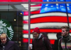 A woman pulls a hood over her head as she walks out of a Starbucks store into the cold wind at Times Square in New York, March 25, 2013. (Photo: Reuters)