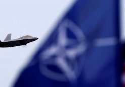 U.S. and North Atlantic Treaty Organization (NATO) flags flutter as U.S. Air Force F-22 Raptor fighter flies over the military air base in Siauliai, Lithuania, April 27, 2016. (Photo: Reuters)