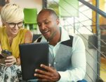 A team of millennial business owners collaborating on an online project using a touchpad tablet in a modern office space. (Photo: AdobeStock/AYAimages)