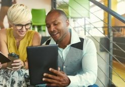 A team of millennial business owners collaborating on an online project using a touchpad tablet in a modern office space. (Photo: AdobeStock/AYAimages)