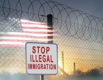 A graphic concept of barbed-wire, chain-linked fencing at the U.S. southern border with a sign reading, 