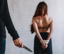 Kidnapping, human and sex trafficking concept of a female hostage and a man holding knife in an abandoned house. (Photo: AdobeStock)