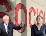 Un mur de propagande, or a propaganda wall, promoting socialism behind Senator Bernie Sanders, D-I, Vt., left, and Alexandria Ocasio-Cortez, D-N.Y., right.