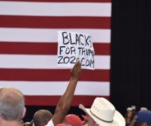 An African American supporter of President Donald Trump holds up a Black for Trump sign during a rally in Tampa, Florida on Tuesday, July 31, 2018. (Photo: Laura Baris/People's Pundit Daily)