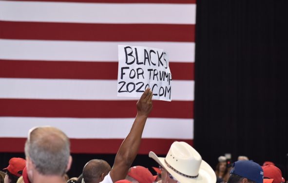 An African American supporter of President Donald Trump holds up a Black for Trump sign during a rally in Tampa, Florida on Tuesday, July 31, 2018. (Photo: Laura Baris/People's Pundit Daily)