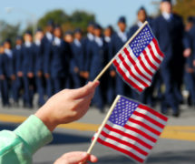 Flag waving at a Veterans Day parade. (Photo: AdobeStock)