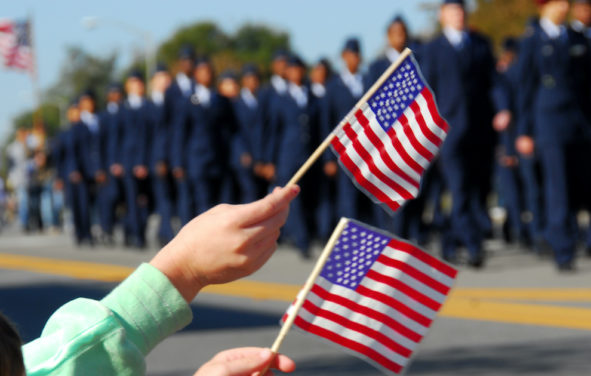 Flag waving at a Veterans Day parade. (Photo: AdobeStock)