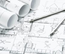 Construction planning drawings on the table and two yellow pencils to illustrate total construction spending data and projects. (Photo: AdobeStock)