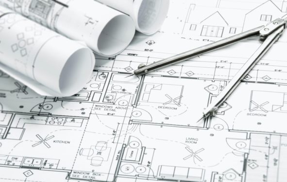 Construction planning drawings on the table and two yellow pencils to illustrate total construction spending data and projects. (Photo: AdobeStock)