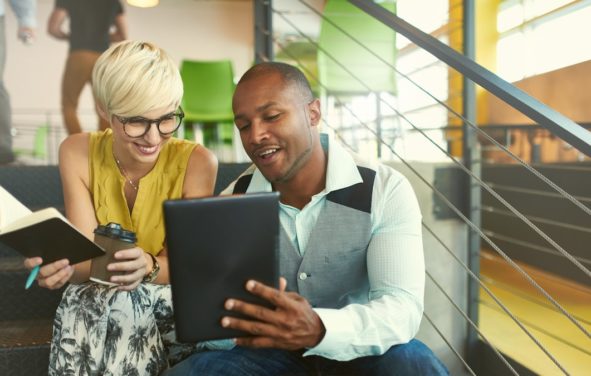 A team of millennial business owners collaborating on an online project using a touchpad tablet in a modern office space. (Photo: AdobeStock/AYAimages)