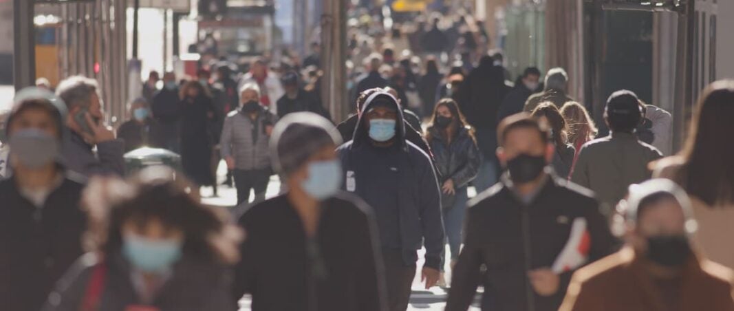 Crowd of people walking the city streets while wearing masks during the coronavirus (Covid-19) pandemic. (Photo: AdobeStock)