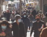 Crowd of people walking the city streets while wearing masks during the coronavirus (Covid-19) pandemic. (Photo: AdobeStock)